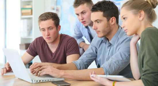 Studenten sitzen an einem Laptop